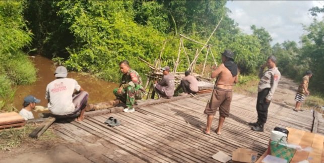 Wujud Kepedulian kepada Masyarakat, Babinsa Bukit Batu Gotong Royong Perbaiki Jembatan